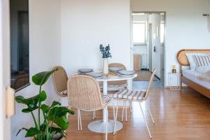 a living room with a table and chairs and a couch at Seeblick Apartment Meersburg in Meersburg