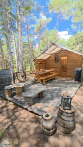 a wooden cabin with a picnic table and a bench at Destination Ailleurs eco-domaine & spa in Castellane