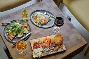 a table with two plates of food and a glass of wine at Hotel Clio, a Luxury Collection Hotel, Denver Cherry Creek in Denver