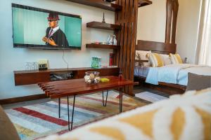 a living room with a tv on a wall at Geza Breeze Residence in Dar es Salaam