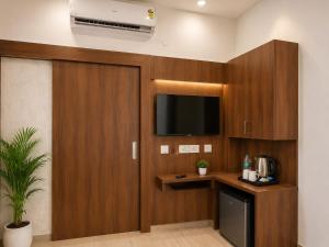 a room with a tv and a wooden wall at The Vacation Villa Agra A Boutique Hotel Near Taj Mahal in Agra