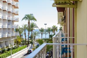 a balcony with a view of the ocean and palm trees at Candisol Cozy Inns in Torremolinos