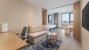 a living room with a couch and a table at Holiday Inn Express Kunming West by IHG in Kunming