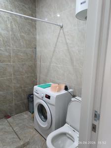 ein Badezimmer mit Waschmaschine und Toilette in der Unterkunft Coldo in Bosteri