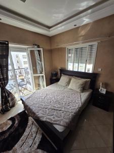 a bedroom with a bed and a window at Dar mayssane in Agadir