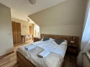 a bedroom with a bed with two towels on it at Kłabuk in Białka Tatrzańska
