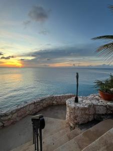 a statue sitting on top of a stone wall next to the ocean at Lagun Paradise Curacao in Willemstad