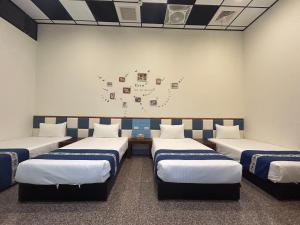 a room with four beds and a wall with drawings on the wall at Sun Moon Lake Jinlongshan BnB in Yuchi