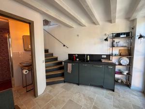 a kitchen with a counter and a staircase at Casa Limone - a due passi dal lago in Castelletto di Brenzone