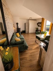 a living room with a green couch and a table at Modern apartment with balcony & panoramic view in Tirschenreuth