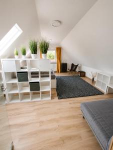 a living room with white shelving and potted plants at Modern apartment with balcony & panoramic view in Tirschenreuth