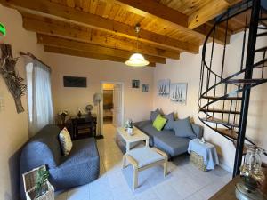 a living room with a blue couch and a spiral staircase at The Great Balcony in Ioulis