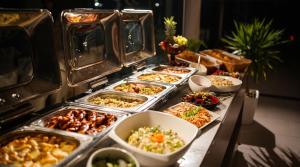ein Buffet mit vielen Tabletts voller Speisen auf einem Tisch in der Unterkunft Hotel Melodia in Venus