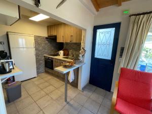 a small kitchen with a blue door and a counter at The Great Balcony in Ioulis
