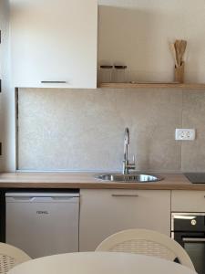 a kitchen with a sink and a table and chairs at Lola Sutomore in Sutomore