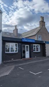 a brick building with a sign that reads ocean breezes inn at Ocean Breeze Inn in Eyemouth
