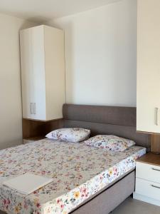 a bedroom with a bed with two pillows and a cabinet at Lola Sutomore in Sutomore