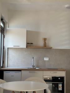 a kitchen with a sink and a table with chairs at Lola Sutomore in Sutomore