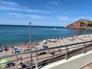 a beach with many umbrellas and people on the beach at Lola Sutomore in Sutomore