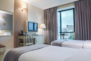 a hotel room with two beds and a window at Amman West Hotel , A Boutique Hotel in Amman +12 photos