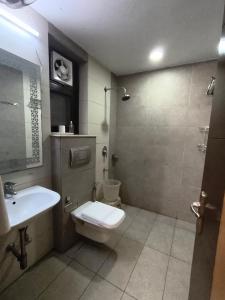 a bathroom with a toilet and a sink at The Hermitage by The Cosy Hotels Near Lotus Temple in New Delhi +34 photos