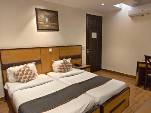 a bedroom with a bed with white sheets and pillows at The Hermitage by The Cosy Hotels Near Lotus Temple in New Delhi
