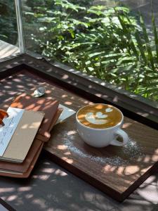 a cup of coffee sitting on a table with a book at Elegance Hotel - Ben Thanh Market - Central HCMC in Ho Chi Minh City +99 photos