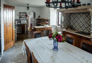 una cocina con una mesa con un jarrón de flores. en Quinta Santo António en Sintra