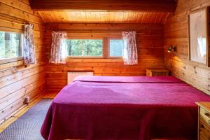 a bedroom with a bed in a wooden cabin at Mökki Kalliola in Puumala
