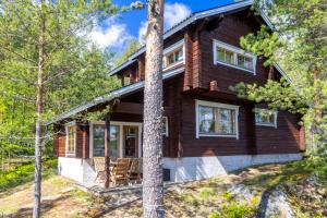 a log cabin with a porch in the woods at Mökki Kalliola in Puumala