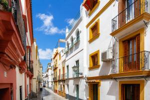 an alley in an old town with colorful buildings at Galera Rooms by SHS in Seville