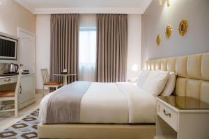 a bedroom with a bed and a desk and a window at Amman West Hotel , A Boutique Hotel in Amman