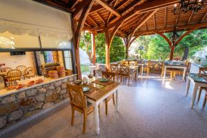 a dining room with tables and chairs and a stone wall at İlkiz Beach Hotel in Oludeniz