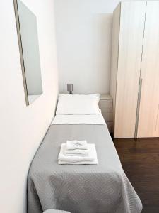 a small room with a bed with a mirror at I Due Gelsi appartamento Green in Monte San Giusto