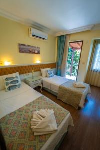 a hotel room with two beds and a window at İlkiz Beach Hotel in Oludeniz