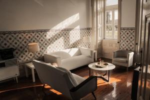 a living room with a couch and chairs and a table at Hotel Jardim in Coimbra