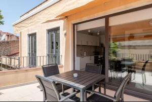 a wooden table and chairs on a balcony at Apartament La Placeta Figueres in Figueres