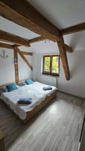 a bedroom with a large bed in a room with wooden beams at Pokoje Gościnne w Spichlerzu in Ustka