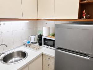 a kitchen with a sink and a stainless steel refrigerator at Apartment 88 SELF check-in, FREE parking in Skopje