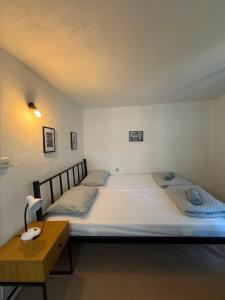 a bedroom with two beds and a wooden table at Bajatova Heritage House with Private Courtyard in Mostar