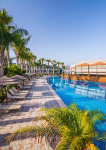 a swimming pool with palm trees and a building at Blue Lagoon Resort in Lampi