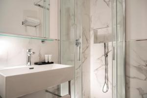 a white bathroom with a sink and a shower at Re Enzo in Bologna