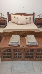 a bed with a wooden table with two towels on it at Μαγευτική βίλα Κωνσταντίνα in Nerántza