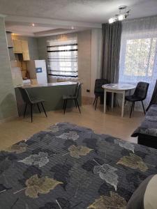 a living room with a kitchen and a table and chairs at Уютная 1 комнатная квартира на Сейфуллина 21 in Balqash