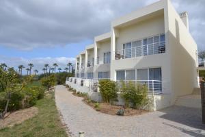 an exterior view of a building with palm trees at Colina Verde Resort in Moncarapacho
