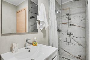 a white bathroom with a sink and a shower at Kallichoron 3 fortezza Kavala in Kavála +35 photos