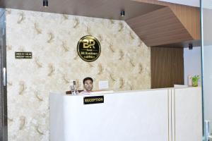 a man sitting at a reception desk in an office at Hotel B R Residency in Bikaner
