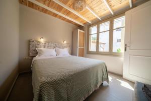 a bedroom with a bed and a large window at Meraki Villa Pelion in Kalamos