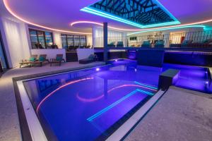 a swimming pool in a building with purple lighting at Nagelschmiede in Münsingen