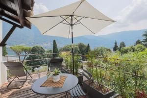 a table and chairs on a deck with an umbrella at The Como Pet Nest in Laglio +19 photos